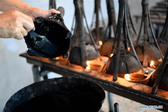 Wang Chunlin, a provincial-level inheritor of traditional handmade oil soot ink making in Anhui, started learning to make oil soot ink from his father at the age of 14. The oil soot inkstick made with traditional techniques from the soot of burnt tung oil or various other oils lines with smooth and bright luster. Along with the inkstone, brush, and paper, the inkstick is considered one of the