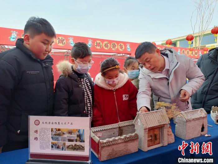 春节期间，潘明生在庙会上为观众介绍砖雕文化。 受访者供图